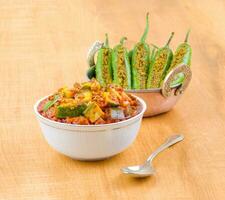 Indian Traditional Raw Mango Pickle With Green Chilli Pickle on Wooden Background photo