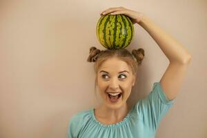 Cute playful woman holding  watermelon on her head.Toned image. photo