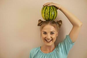 Cute playful woman holding  watermelon on her head.Toned image. photo