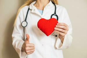 Image of female doctor showing heart and thumb up. photo