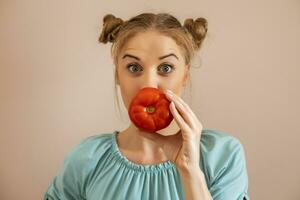 Portrait of cute playful woman holding tomato.Toned image. photo