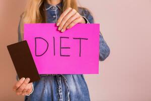 mujer participación chocolate y papel con palabra dieta.it es hora para dieta y sano comiendo concepto foto