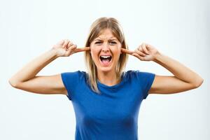 Angry woman screaming and covering her ears photo