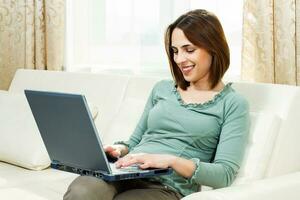 Woman using laptop at home photo
