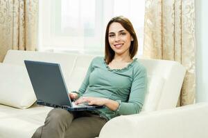 mujer usando laptop en casa foto