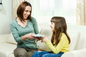 hija dando regalo a su madre foto