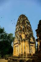 birds flying over the ruins of an ancient temple photo