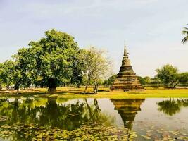 a pagoda in the middle of a pond with water lillies photo