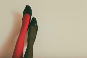 hermosa piernas de un mujer en en diferente color medias y alto tacones arriba en frente de pared.tonificada foto