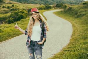 hermosa joven mujer autoestop a el país la carretera. foto