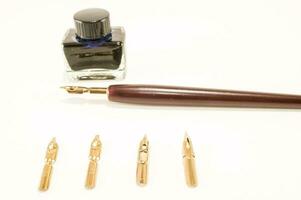 a fountain pen, nibs and a bottle of ink photo