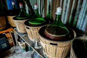 wine bottles in barrels in a cellar photo