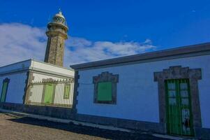 a white building with green doors and a tall tower photo