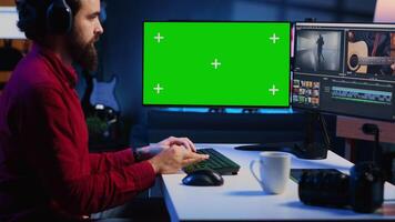 Videographer using professional software on chroma key PC to create visual effects for video projects. Expert using post production techniques to edit raw clips footage on isolated screen monitor