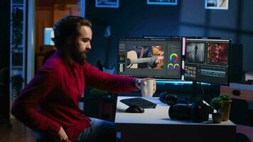 camarógrafo llegando a trabajo en medios de comunicación agencia oficina, Listo a comienzo color de corrección crudo imágenes. vídeo editor edición vídeo renders mientras Bebiendo , utilizando software a hacer montaje desde clips video