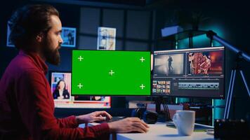 Videographer using professional software on mockup PC to create visual effects for video projects. Expert using post production techniques to edit raw clips footage on green screen computer photo