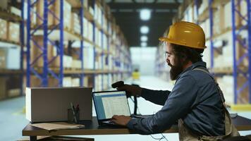 Delivery supervisor scanning barcodes for product logistics, managing delivery requirements with warehouse scanner. Factory employee reviewing parcel labels in warehouse, quality control. photo