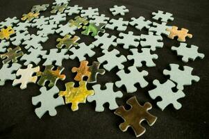 a pile of puzzle pieces on a black surface photo