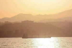 a boat is sailing in the water at sunset photo