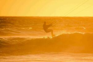 a man kite boarding in the ocean at sunset photo