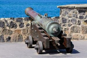 an old cannon on display near the ocean photo