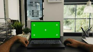 POV of young man sitting at desk and working with isolated greenscreen layout, solving business operations in agency office. Manager checking blank chromakey display or copyspace template. photo