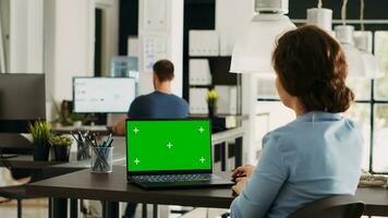 Startup worker checks greenscreen on pc working in creative agency open space office, looking at blank mockup display. Specialist analyzing isolated chromakey display at work. photo