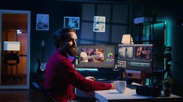 Portrait of happy working on film montage in creative office, editing color grading and lighting. Smiling post production studio worker manipulating raw footage, doing adjustments video