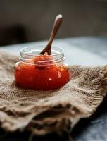 Glass jar with delicious red caviar photo