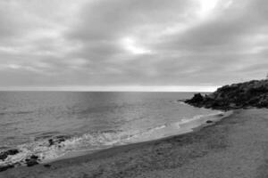 black and white photo of the ocean and beach