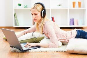Woman with headphones using laptop photo