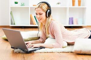 Woman with headphones using laptop photo