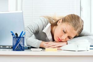 Tired businesswoman sleeping at work photo