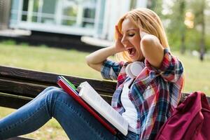 Female student in panic while studying outdoor. photo