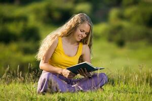 Woman reading book in nature photo