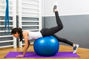 Beautiful young woman exercising with pilates ball. photo