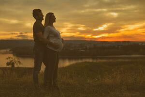 Husband and pregnant wife enjoy spending time together outdoor.Toned image. photo