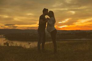 marido y embarazada esposa besos mientras ellos disfrutar gasto hora juntos al aire libre imagen. foto