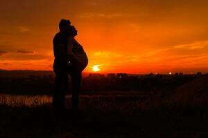 siluetas de marido y embarazada esposa disfrutar gasto hora juntos al aire libre imagen. foto