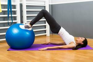 Beautiful young woman exercising with pilates ball. photo