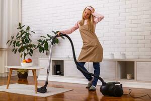 Image of tired housewife with vacuum cleaner  in the living room. photo