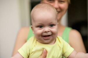 madre disfruta participación su pequeño alegre bebé chico. foto