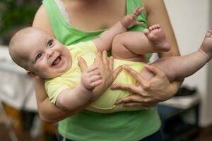 madre disfruta participación su pequeño alegre bebé chico. foto