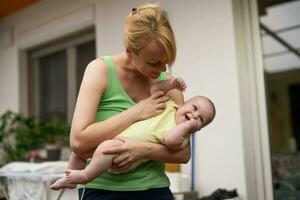 Mother enjoys holding her little cheerful baby boy. photo