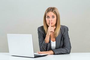 Portrait of beautiful business woman with finger on her lips. photo