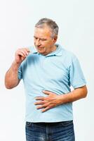 Senior man taking pills for stomachache photo