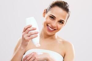 Woman applying cream on her skin photo