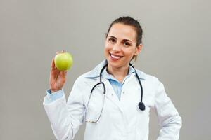 Beautiful female doctor is showing apple photo