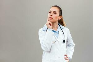 Portrait of beautiful female doctor thinking. photo