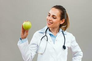Beautiful female doctor is showing apple photo